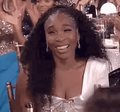 Woman In White Dress Smiling At Table GIF