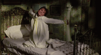 Woman In White Dress Stretching On Bed GIF