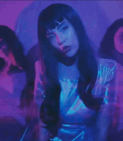 Mujer de vestido blanco rodeada de luz azul GIF