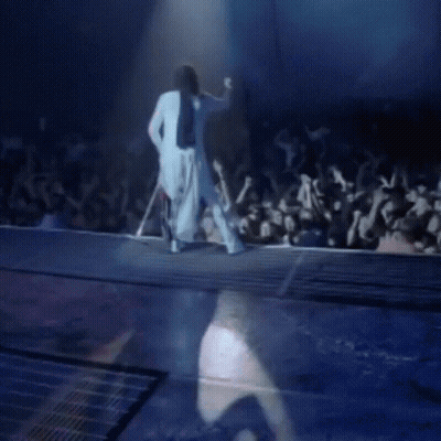 Woman In White Dress Walking Down Stage Before Crowd GIF