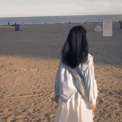 Woman In White Dress Walking On Sandy Beach GIF
