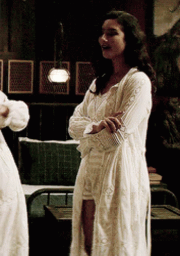 Woman In White Dress With Arms Crossed In Dark Room GIF
