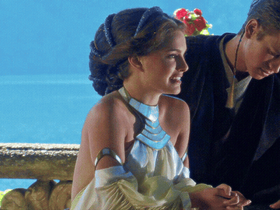 Woman In White Dress With Blue Necklace Sitting Next To Man GIF