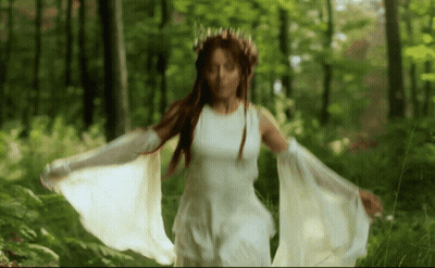 Woman In White Dress With Crown Walking Through Woods GIF