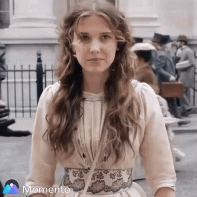 Woman In White Dress With Floral Belt In Front Of Crowd GIF
