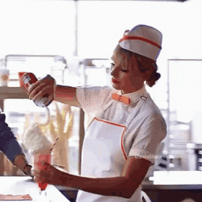 Woman In White Hat And Apron Pouring Whipped Cream Into Cup GIF