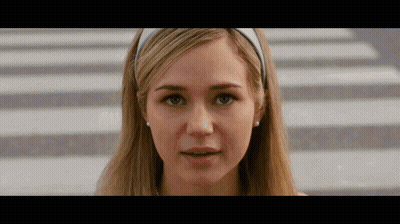 Woman In White Headband And Earrings Looking At Camera GIF