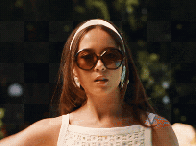 Woman In White Headband And Sunglasses Looking At Camera GIF