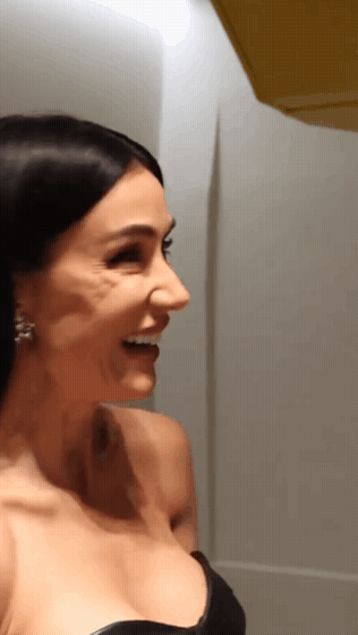 Woman In White Jacket At Microphone In Dark Room GIF