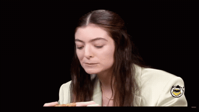 Woman In White Jacket Eating Pizza Saying Delicious Wang GIF