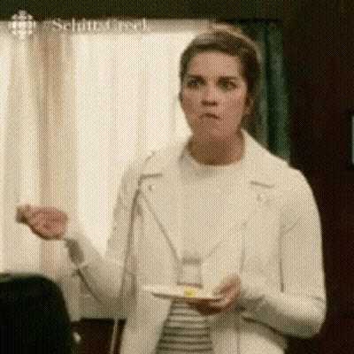 Woman In White Jacket Holding Plate Of Food GIF