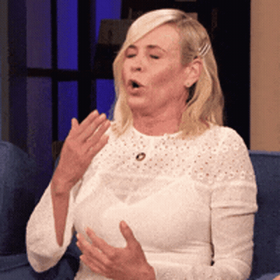 Woman In White Lace Top Sitting On Blue Couch Mouth Open GIF