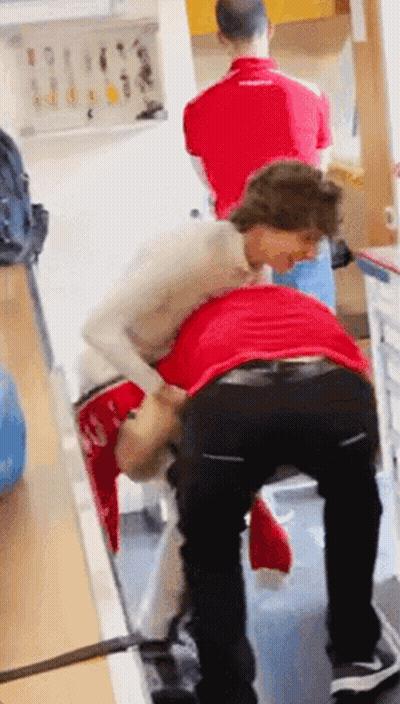 Woman In White Lifting Man In Red GIF