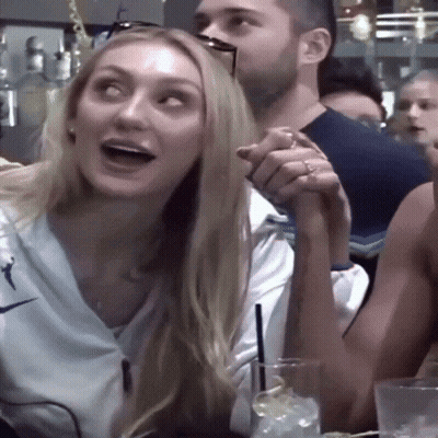 Woman In White Nike Shirt Holding Man's Arm GIF