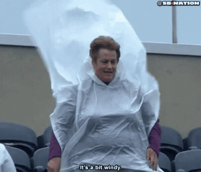 Woman In White Poncho Says It Is A Bit Windy GIF