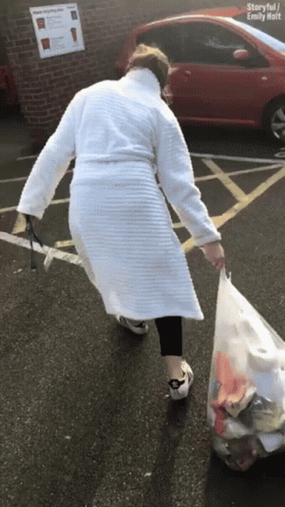 Woman In White Robe Carrying Trash Bag GIF