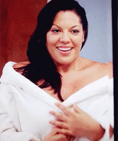 Woman In White Robe Smiling At Camera GIF