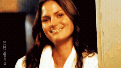 Woman In White Robe Smiling In Front Of Crave2023 Sign GIF