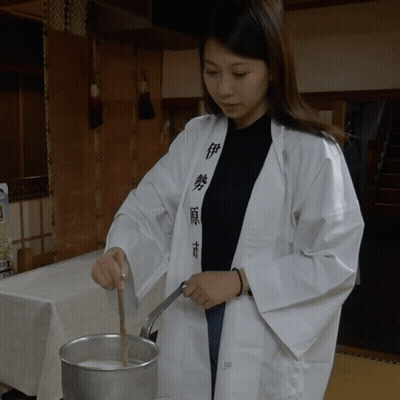 Woman In White Robe Stirring Pot GIF