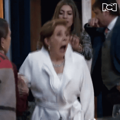 Woman In White Robe With Mouth Open Surrounded By People GIF