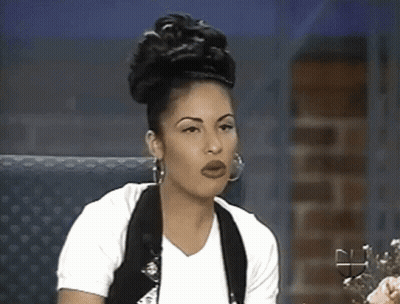 Woman In White Shirt And Black Vest Sitting In Chair GIF