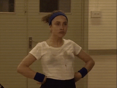 Woman In White Shirt And Blue Headband At Door GIF