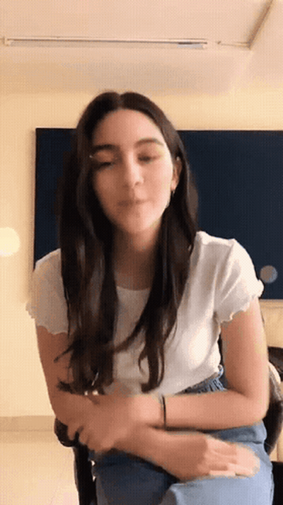 Woman In White Shirt And Blue Jeans Sitting GIF