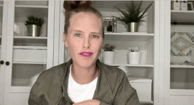 Woman In White Shirt And Green Jacket With Potted Plants GIF