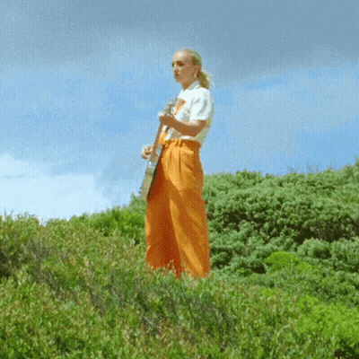 Woman In White Shirt And Orange Pants Playing Guitar GIF
