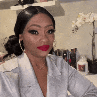 Woman In White Shirt And Red Lipstick Sitting By Candle GIF