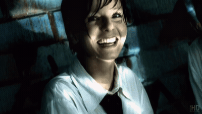 Woman In White Shirt And Tie Smiling In Front Of IHD Sign GIF