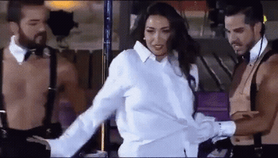 Woman In White Shirt Between Two Shirtless Men In Suspenders GIF