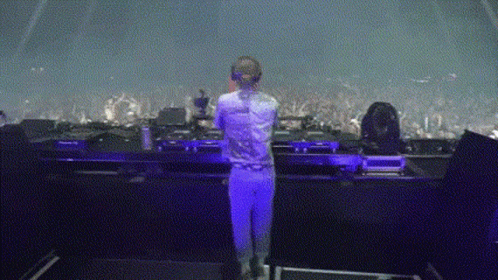 Woman In White Shirt In Front Of Purple Stage Lights GIF