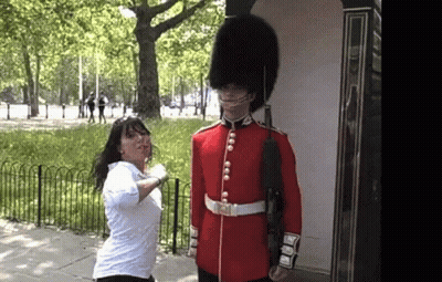 Woman In White Shirt Next To Man In Red Uniform GIF