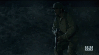Woman In White Shirt Pointing Gun At Man In Showcase Ad GIF