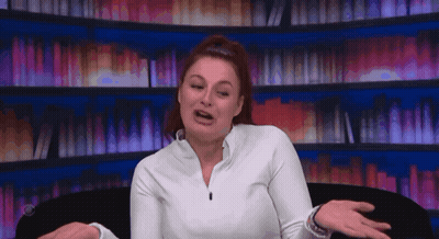 Woman In White Shirt Sitting By Bookshelf GIF