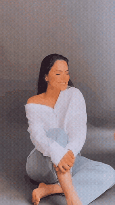 Woman In White Shirt Sitting Cross-Legged Eyes Closed GIF