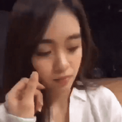 Woman In White Shirt Sitting With Eyes Closed GIF