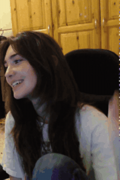 Woman In White Shirt Smiling In Front Of Wooden Cabinet GIF