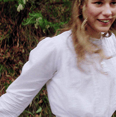 Woman In White Shirt Smiling In Grass GIF