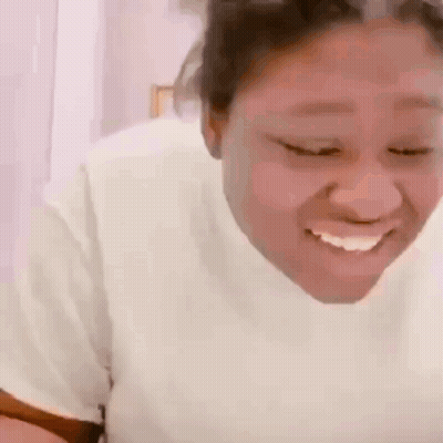 Woman In White Shirt Smiling Looking Down GIF