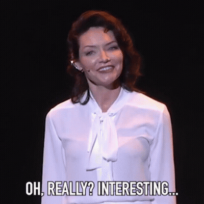 Woman In White Shirt Smiling On Stage GIF