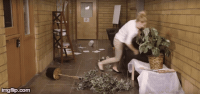 Woman In White Shirt Standing In Hallway With Potted Plant GIF