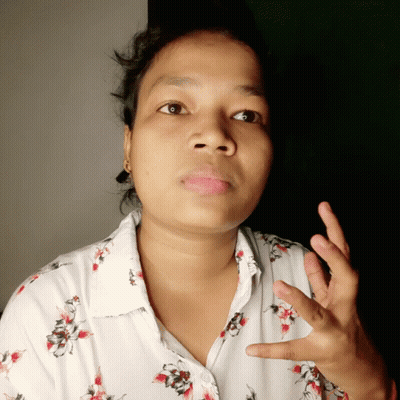 Woman In White Shirt With Red And Black Flowers Making Funny Face GIF
