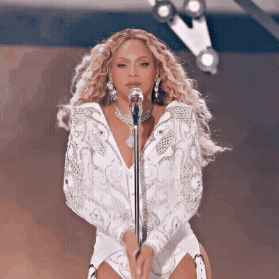 Woman In White Singing Into Microphone GIF