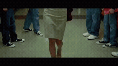 Woman in White Skirt Walking Through Crowded Hallway