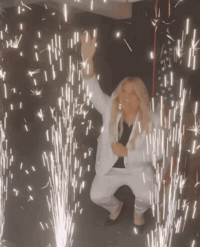 Woman In White Suit Dancing Fireworks GIF
