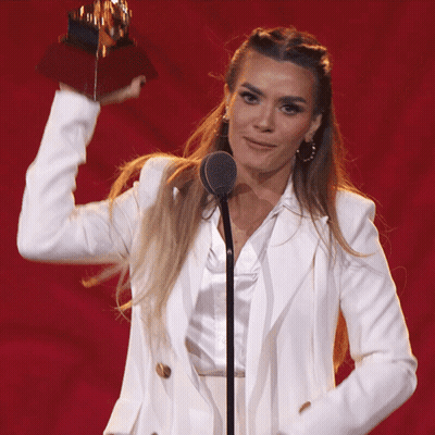 Woman In White Suit Holding Trophy GIF