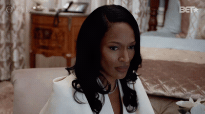 Woman In White Suit Sitting On Bed With Bet GIF
