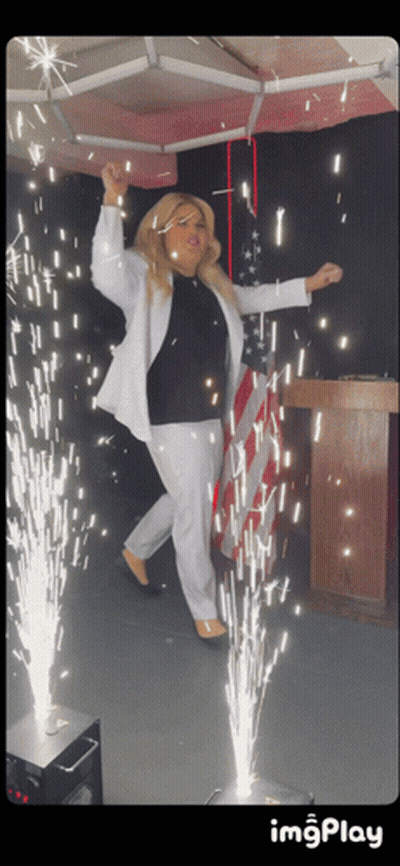 Woman In White Suit With Sparkler Podium GIF